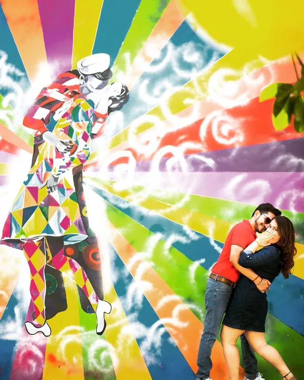 A fun and energetic couple shoot against a vibrant graffiti wall. This kind of environmental portraiture allows couples to express their personality, and the bright colors create a dynamic and modern love story.