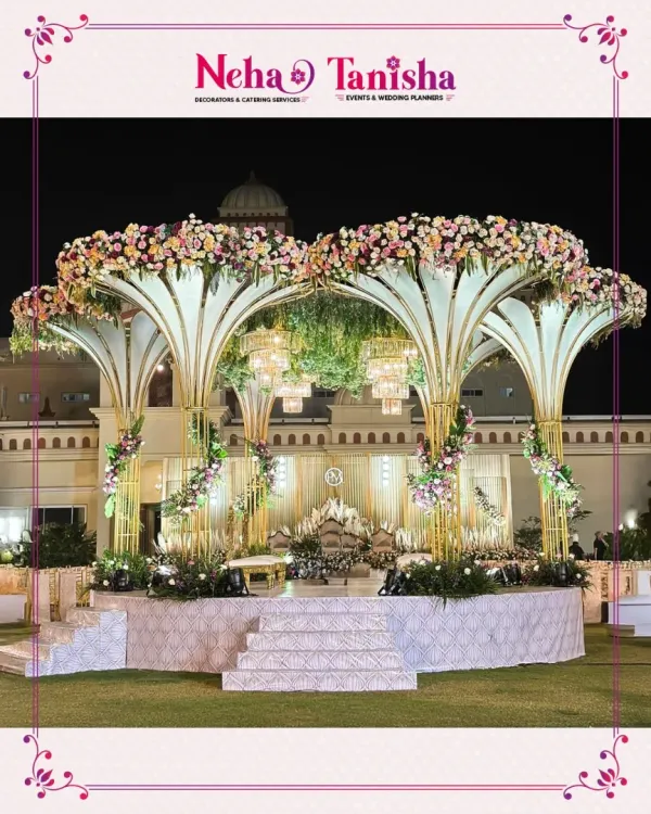 We believe your wedding stage should be nothing short of a masterpiece. This grand floral canopy, illuminated by elegant chandeliers, creates a breathtaking focal point for an unforgettable outdoor reception.