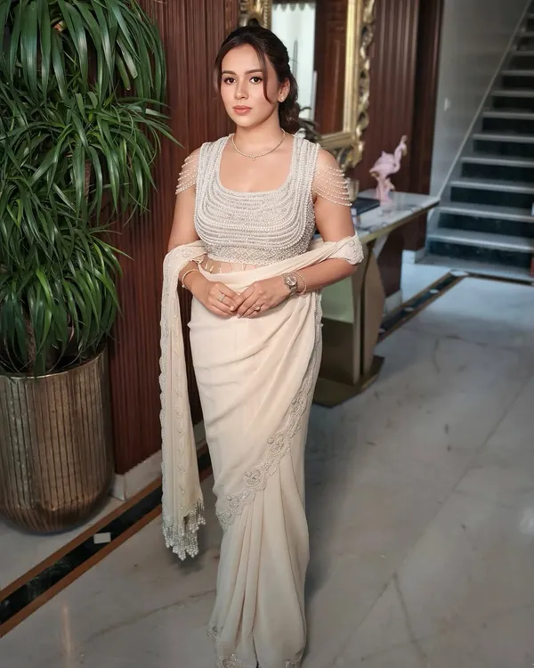 Elegance in every detail. This look redefines minimal with a touch of class and quiet luxury, featuring clean makeup and a chic hairstyle to complement a modern designer saree.