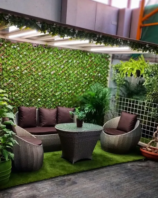 Our garden centre is designed to be an oasis. This seating area, complete with comfortable garden furniture and surrounded by artificial green walls, shows how you can create a serene outdoor living space.