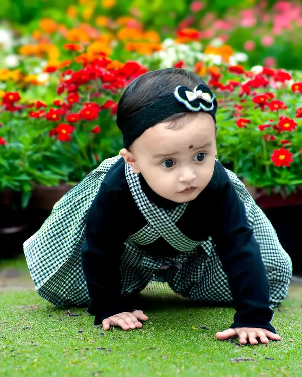 A curious toddler exploring a garden full of colorful flowers. This candid baby photoshoot captures the wonder of discovery in a natural, outdoor setting.