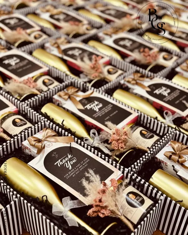 These elegant return gifts are perfect for a sophisticated celebration. The black and white striped boxes contain a miniature bottle and gourmet chocolates, finished with a personalized "Thank You" card, making guests feel truly appreciated.