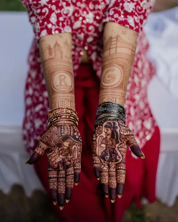A perfect couple shot showing the bride's portrait mehendi and the groom's simpler initial design. This design also features the skylines of Bangalore and San Francisco.