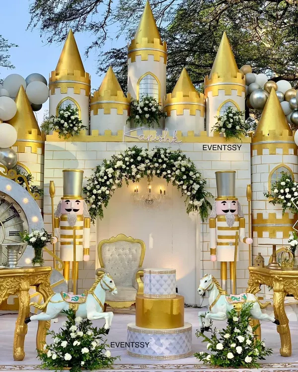 A magnificent royal castle backdrop for a prince's birthday, complete with golden turrets, nutcracker guards, and a floral arch. This setup is designed to be a grand stage for the celebration's main events, including the cake cutting.