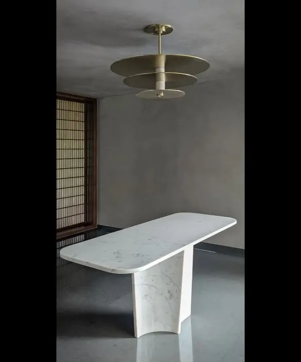 This ceiling light, designed for an entrance foyer, combines marble and brass to make a strong first impression. The tiered design plays with reflection and light, acting as a functional sculpture.