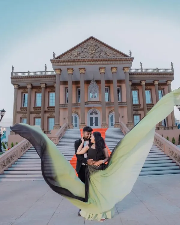A fairytale moment captured perfectly. For this pre-wedding shoot, I styled the couple with a dramatic flying trail gown and a classic black suit to create a stunning contrast against the grand architecture.
