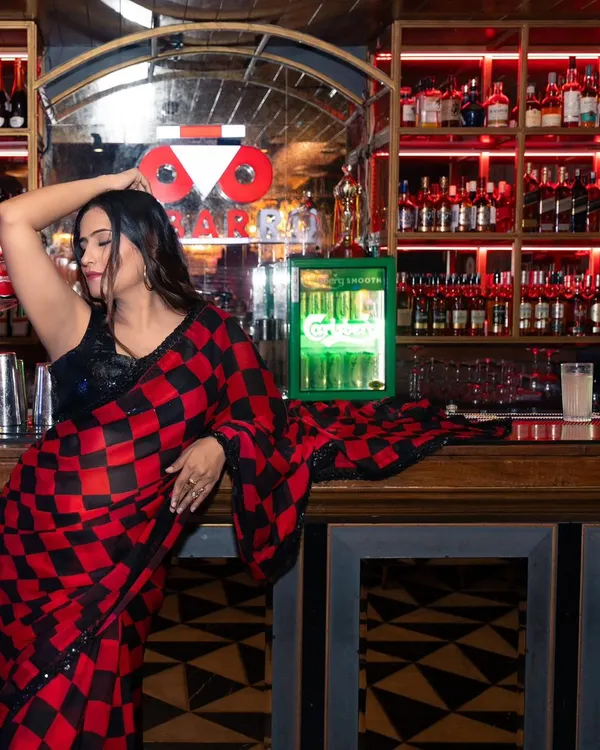 A lifestyle shoot for a fashion influencer at a stylishly lit bar. I use the location's ambiance to create a moody and sophisticated backdrop that complements the modern-ethnic outfit.