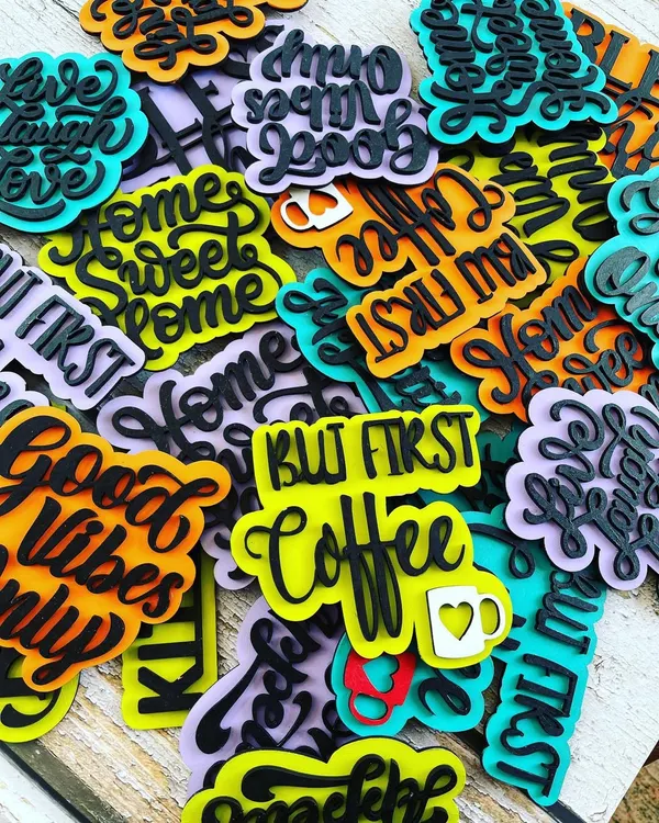 We launched a new collection of hand-painted decorative magnets! This pile shows the variety of fun quotes and bright colors available, perfect for decorating your fridge, office cabinet, or any metal surface.