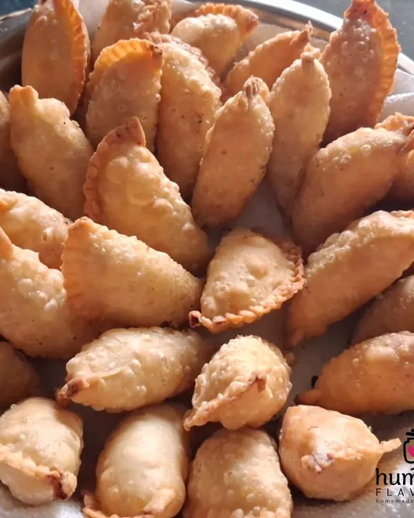 A tray piled high with my signature Mawa Gujiyas, the star sweet of Holi. Each one is handmade with a rich filling of mawa and dry fruits, then fried to golden perfection. It's a taste of tradition that brings so much joy during the festival of colors.