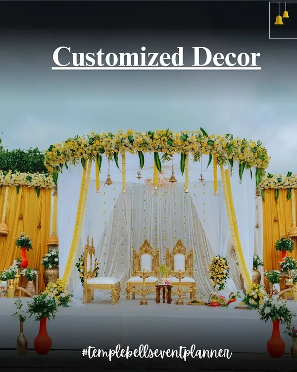 A classic South Indian wedding mandap we designed, showcasing our customized decor services. The setup features traditional yellow and white colors, ornate seating for the couple, and beautiful floral arrangements.