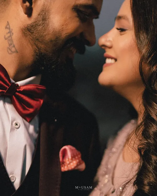 A perfect close-up capturing the joy and intimacy of an engagement. The couple's bright smiles and close embrace, with his stylish red bow tie adding a pop of color, make this a heartwarming portrait.