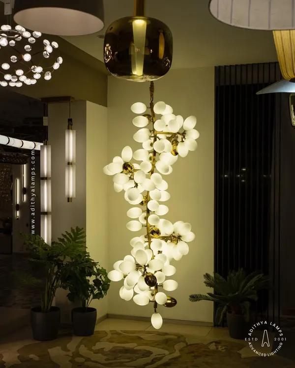 A true centerpiece, this double-height chandelier features a cascade of white and gold ovals. It is designed to fill grand foyers and living spaces with a spectacular, diffused light that is both impressive and welcoming.