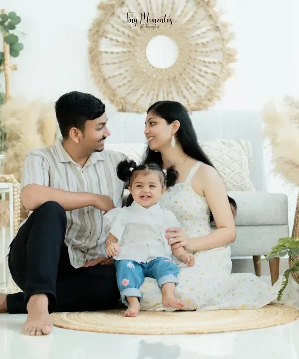 Happiness is being nestled between mom and dad. This full family portrait in my boho setting showcases a beautiful moment of connection, with natural textures adding warmth to the scene.