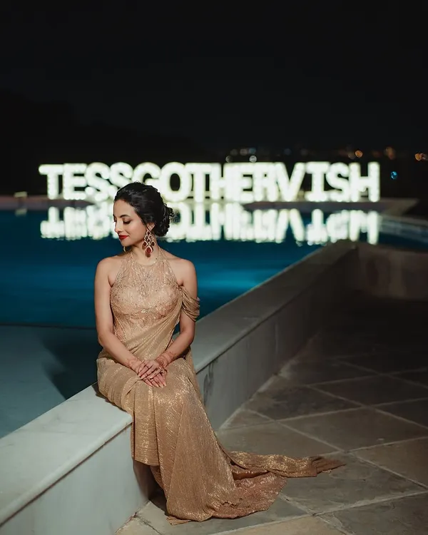 A vision for her reception night. Tessa’s look was pure glamour, with a bold red lip, shimmering gold eyes, and an elegant updo that complemented her stunning Tarun Tahiliani gown.