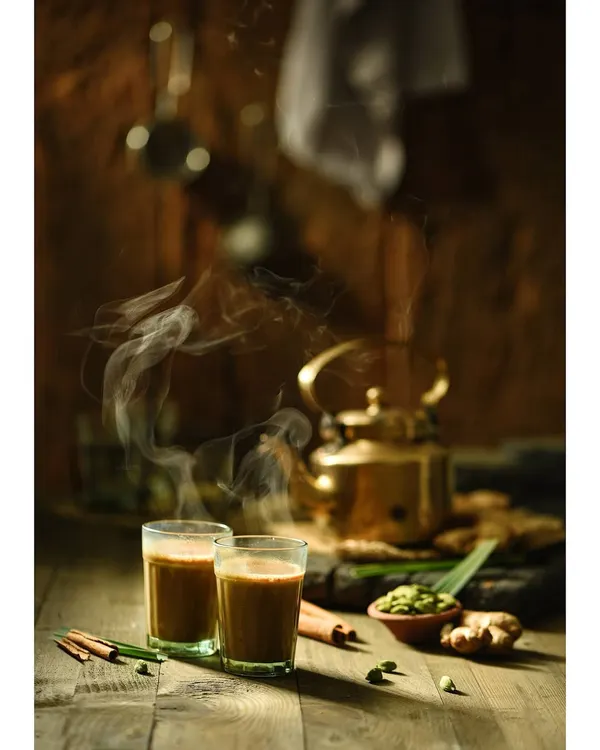 This is a classic still life food photograph. I used dark, moody lighting and captured the rising steam to create a warm, inviting atmosphere that evokes the comfort of Indian chai.