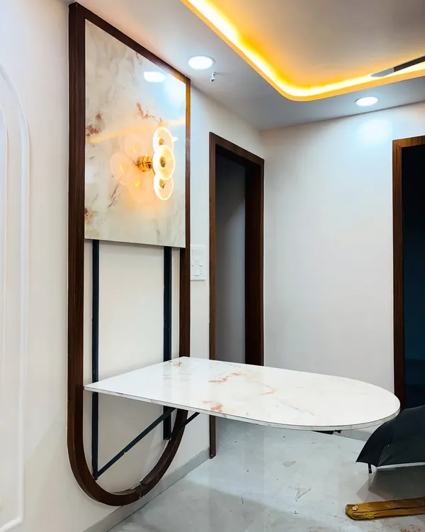 A perfect example of our space-saving furniture: a wall-mounted dining table. This unit features a marble-finish top that folds down, supported by a sturdy metal frame, and is complemented by a decorative backlit panel above.