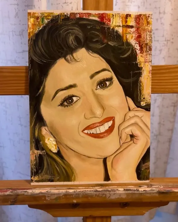A finished oil portrait of the actress Madhuri Dixit on a canvas sheet, set against an abstract, textured background. I focused on capturing her iconic smile and expressive eyes.