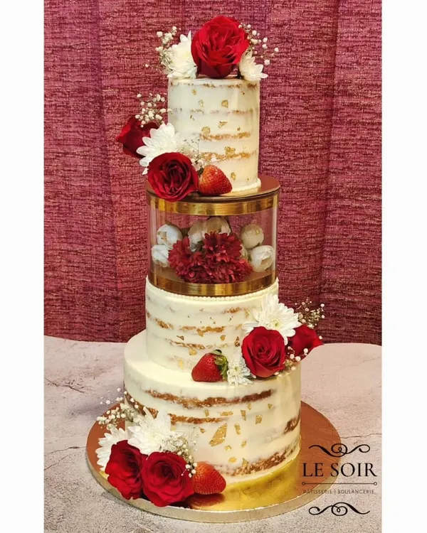 This beautiful three-tier semi-naked wedding cake was a joy to create. Made with a Vanilla Strawberry flavor, it features delicate fresh flowers, baby's breath, and touches of gold leaf for an elegant, rustic finish perfect for a wedding reception.
