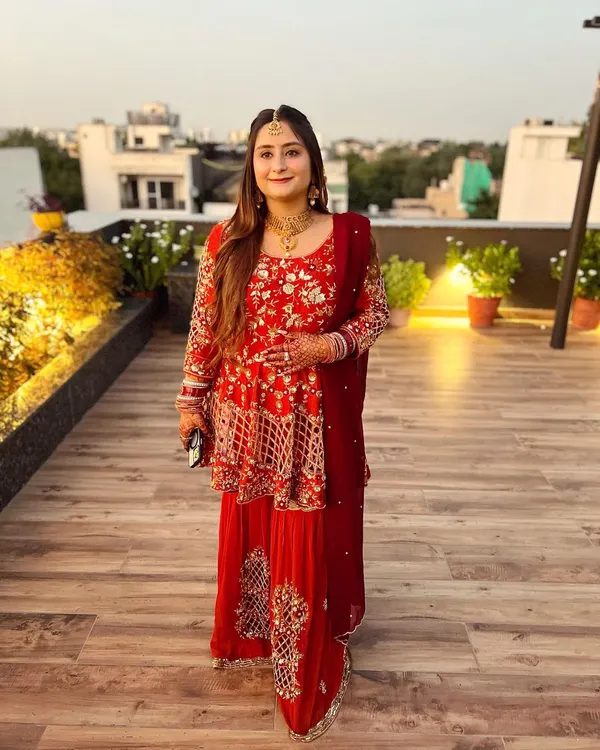 A beautiful bride-to-be at her pre-wedding function. She is wearing a surreal burnt orange and maroon gharara with a peplum top, all hand-embroidered with finesse.