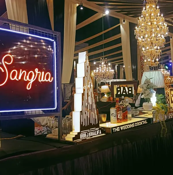 A beautiful and inviting Sangria bar setup. The bright neon sign and elegant decor make it a popular spot for guests to relax and enjoy a refreshing drink.