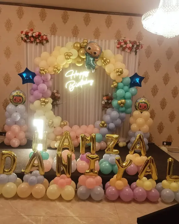 A Cocomelon stage setup for Danial's first birthday. I used pastel balloons to create a soft and cheerful look, with character balloons and a neon "Happy Birthday" sign.