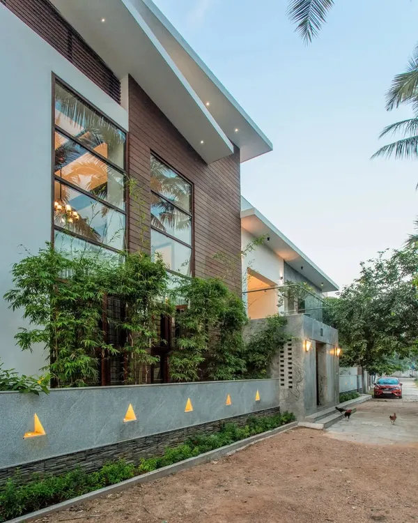 The renovated facade of the Eco Terre residence. We retained the original plinth of the 33-year-old home and built a new, modern structure that incorporates large windows and natural materials like wood and stone.