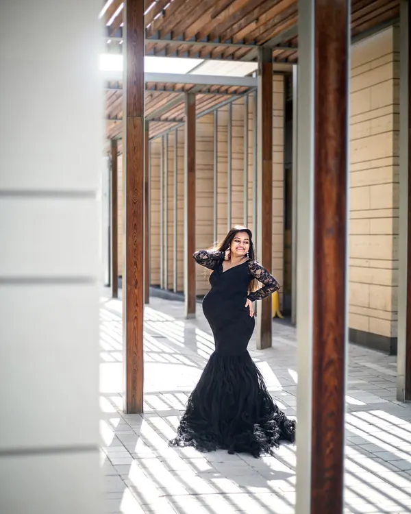 A stunning solo portrait in Dubai, using modern architecture and dramatic shadows to create a high-fashion maternity look.
