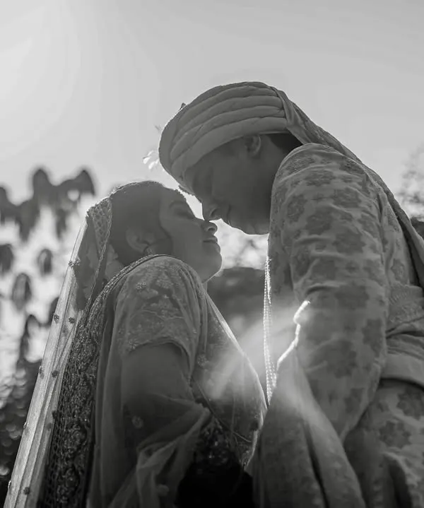 A dramatic black and white silhouette of a couple, backlit by the sun. This technique creates a timeless and romantic portrait, focusing on their connection.
