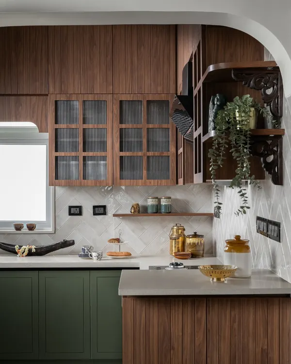 This kitchen proves that functional spaces can also be the most beautiful. I paired rich olive green cabinetry with warm wood tones and fluted glass to create a modern-traditional feel. The gentle archway and carved wooden brackets are details that add a layer of handcrafted charm.