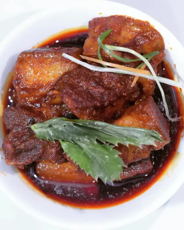 A bowl of my classic pork curry, made with tender chunks of meat in a dark, savory sauce. This dish is a staple and represents the core flavors of my home cooking.
