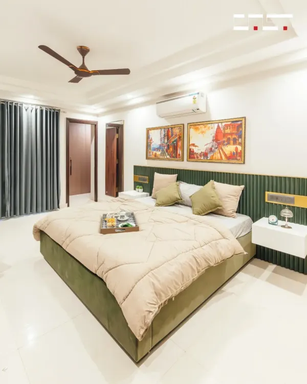 This bedroom in a Jaipur apartment features a custom-fluted green headboard and floating bedside tables. The design combines minimalist forms with rich textures and warm colors to create a cozy yet modern retreat.