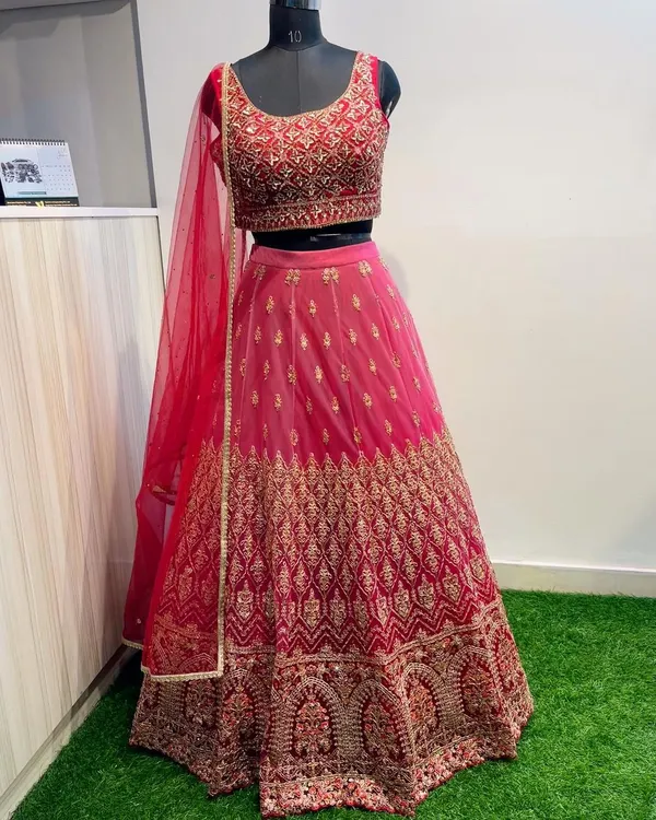 This Maharani pink lehenga is a showstopper, featuring dense gold embroidery on both the blouse and skirt. It's a timeless and elegant choice for a wedding guest who wants to make an impression.