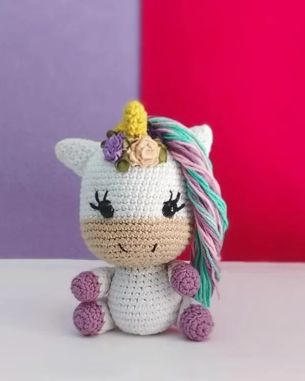 This mini unicorn is ready to spread some magic. I adorned her with a crown of little flowers and gave her a colorful mane with pastel yarn.