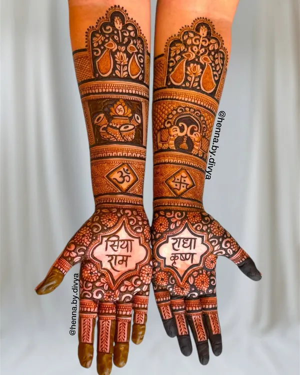 A divine bridal mehendi design featuring "Siya Ram" and "Radha Krishna" on the palms. The full-arm design is packed with auspicious symbols like the kalash, Om, swastika, and elephants, perfect for a traditional bride.