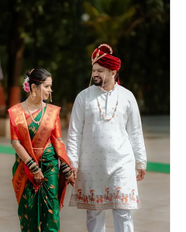 A classic portrait of a Maharashtrian couple on their wedding day, holding hands as they begin their new journey together.