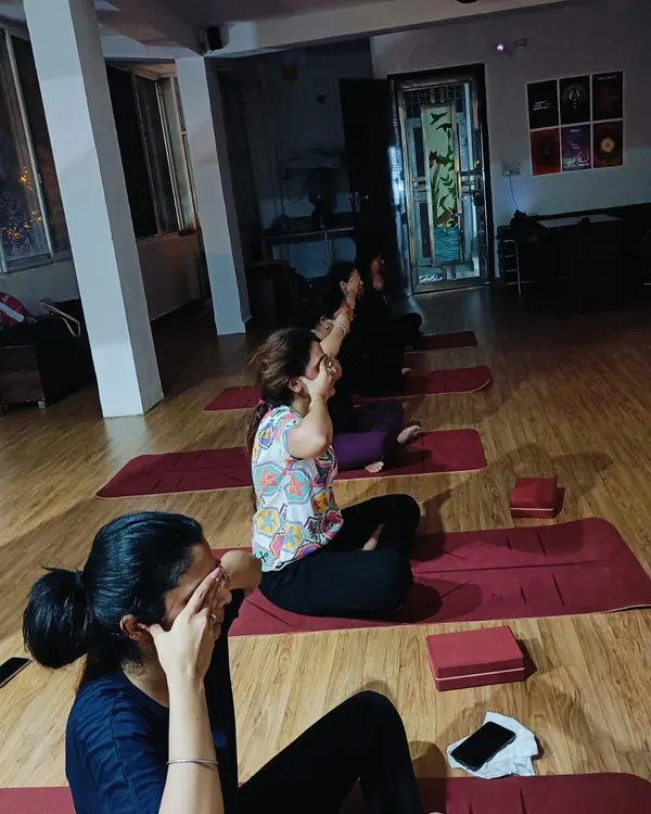 Students practicing a form of pranayama, likely Nadi Shodhana, to calm the nervous system and balance the mind at the start or end of class.