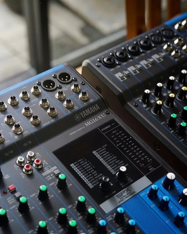 A close-up of the Yamaha MG16XU audio mixer. This shot highlights the high-quality D-PRE mic preamps and rugged metal chassis, built for reliable performance in the studio or on the road.