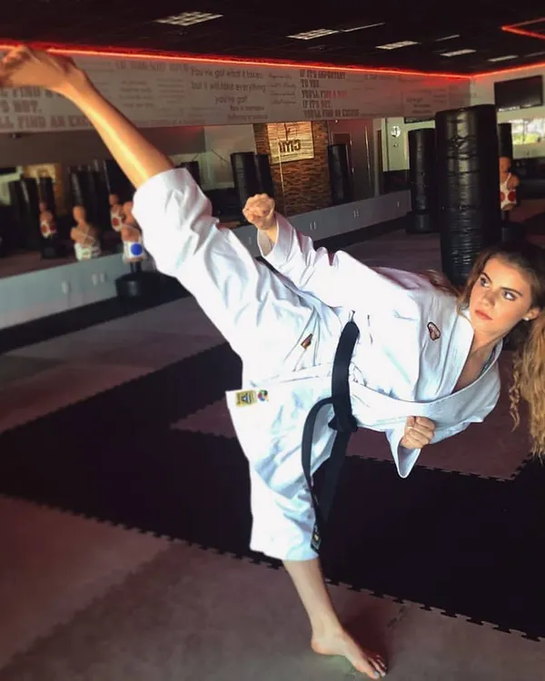 A black belt is more than an accessory; it represents countless hours of dedication. Here, one of my senior students demonstrates a flawless high kick, a testament to the precision and power we cultivate in our karate training.