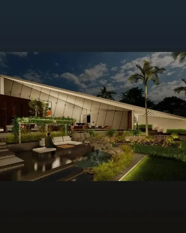A stunning farmhouse design where the architecture follows the function. The dramatic sloped roofline and extensive use of glass create a modern silhouette against the night sky, overlooking a tranquil, beautifully lit landscape.
