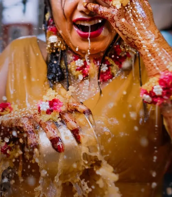 The sheer joy of a bride during her Haldi ceremony, captured in a moment of playful celebration. We love the energy and vibrant colors of these events.