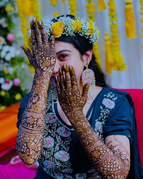 A beautiful, happy bride peeking through her intricately designed hands. Her joy is what makes my work so rewarding.