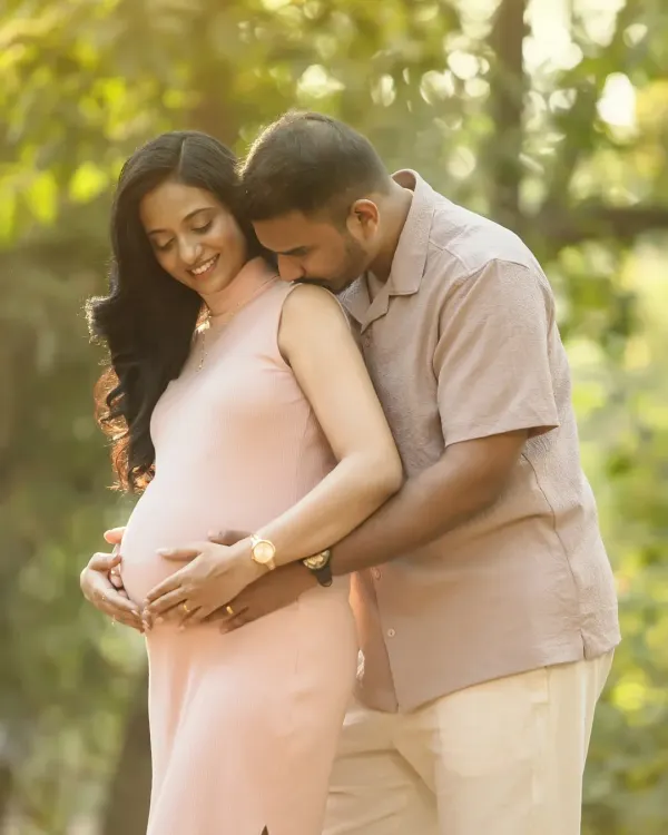 A sweet kiss and a loving embrace, surrounded by the beauty of nature. The golden hour light makes this outdoor maternity portrait feel extra warm and romantic.
