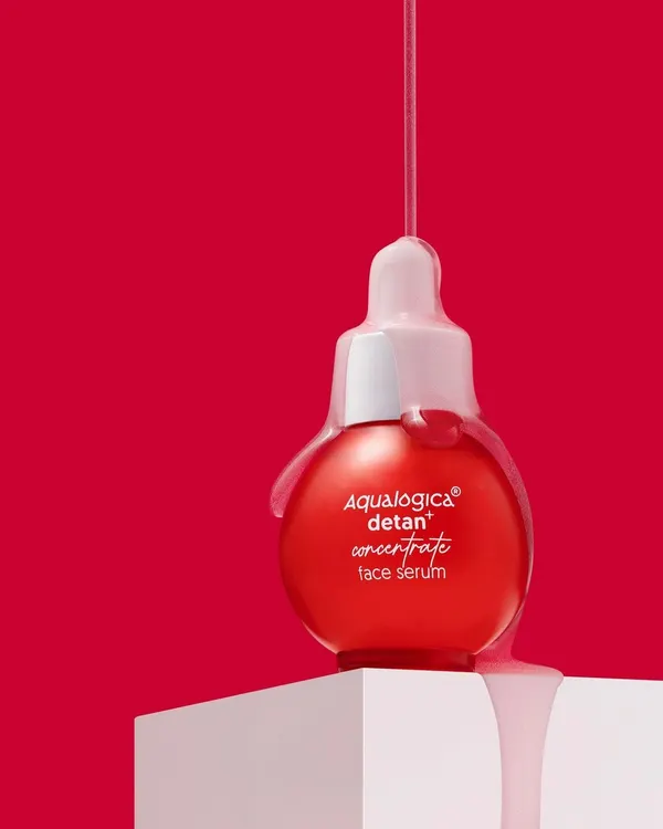 This shot is all about capturing that perfect, glossy drip. We used a bold red background and precise lighting to highlight the serum's texture as it cascades over the bottle, creating a visually arresting image that screams luxury.