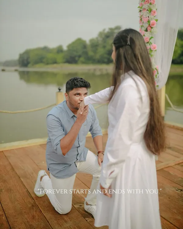 "Forever starts and ends with you." A classic proposal moment, with the groom down on one knee, kissing her hand on a beautifully decorated pier at Honeybook Studios.