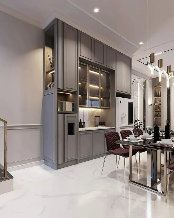 This elegant, floor-to-ceiling crockery unit in a matte grey finish provides extensive storage. It features a mix of closed cabinets, glass-fronted display sections with internal lighting, and a dedicated niche for a microwave or coffee machine.