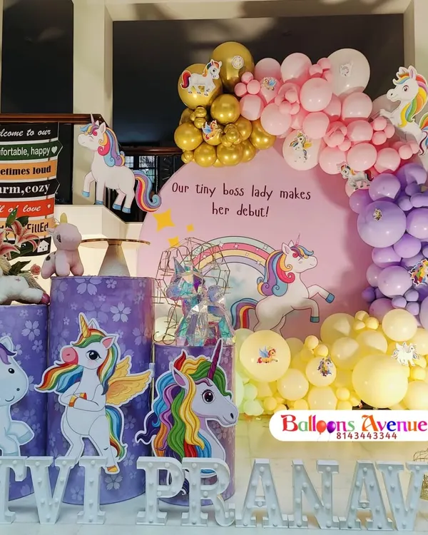 A magical unicorn-themed birthday party, perfect for a "tiny boss lady's debut." This setup features unicorn cutouts, a rainbow backdrop, and themed pedestals.