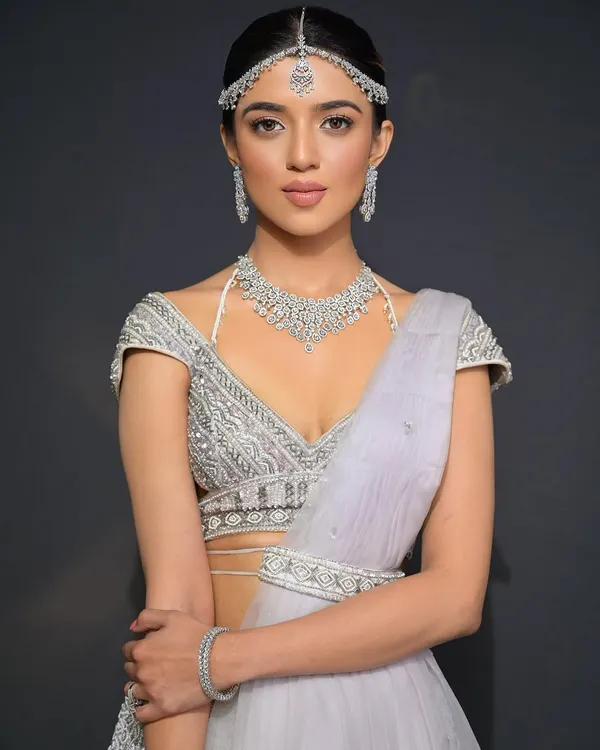 A stunning bridal look for a modern bride. The sleek, low bubble braid is accessorized with a diamond matha patti for a look that is simple, elegant, and incredibly chic.