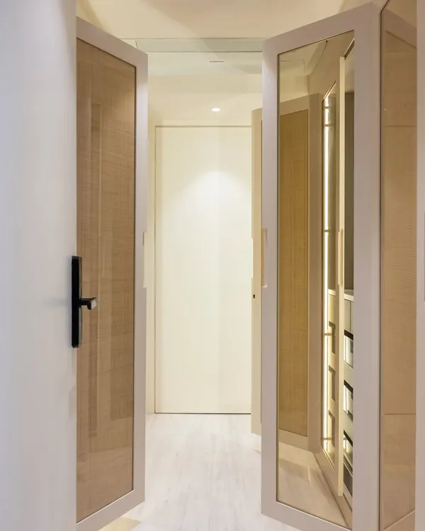 This is where my #BeyondKitchen approach comes to life. This walk-in closet was designed with the same care as a kitchen, with mirrored and wicker-paneled doors that create a space that feels light, textured, and deeply personal.