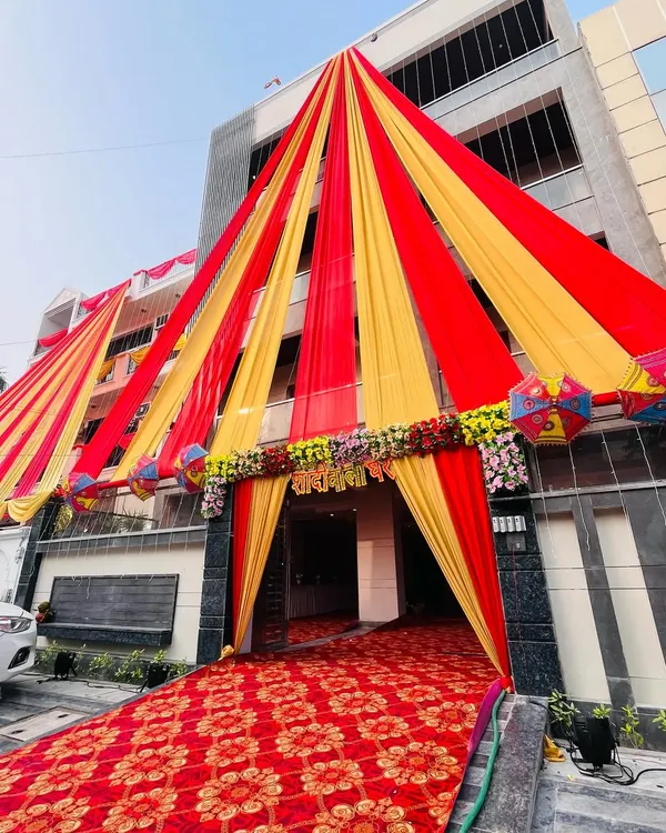 A grand entrance decoration for a wedding house. I used red and yellow drapes to create a massive, welcoming tent structure that makes a statement.
