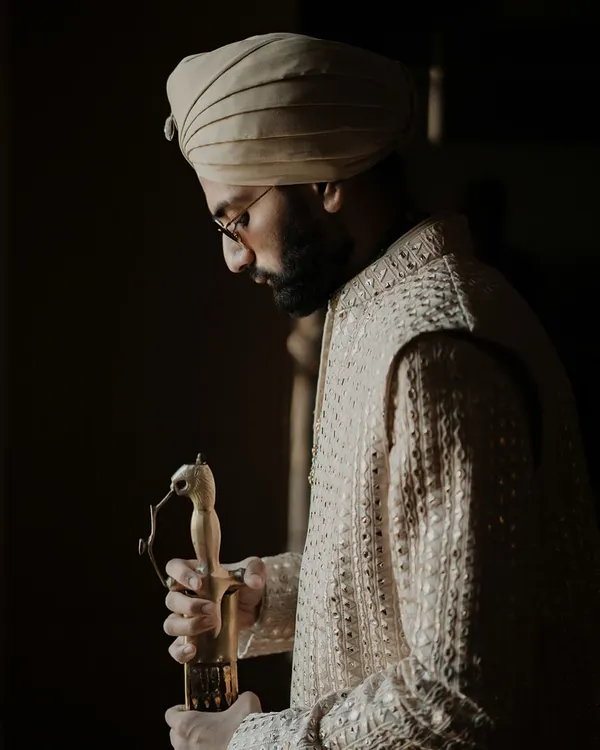 Elegance personified. This portrait of the groom captures a moment of quiet reflection, redefining royal charm and showcasing the intricate details of his wedding attire.